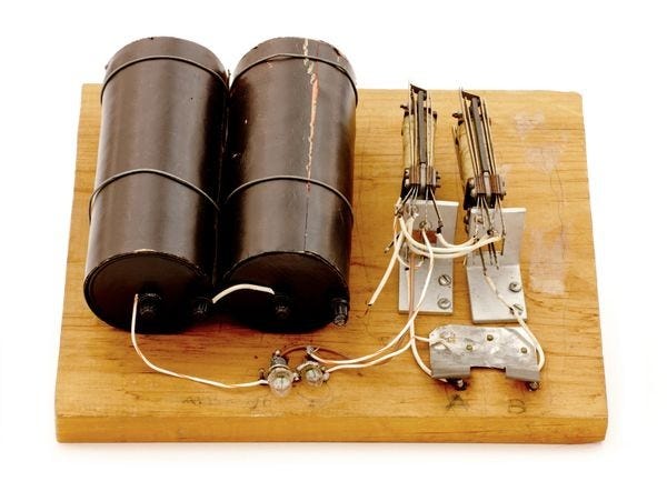 A replica of the Model K relay adder: two batteries and relay switches on a wooden board.